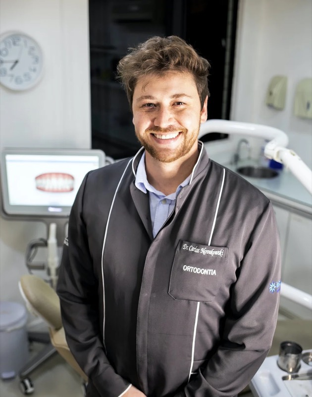 A dentist beside a dental scan screen